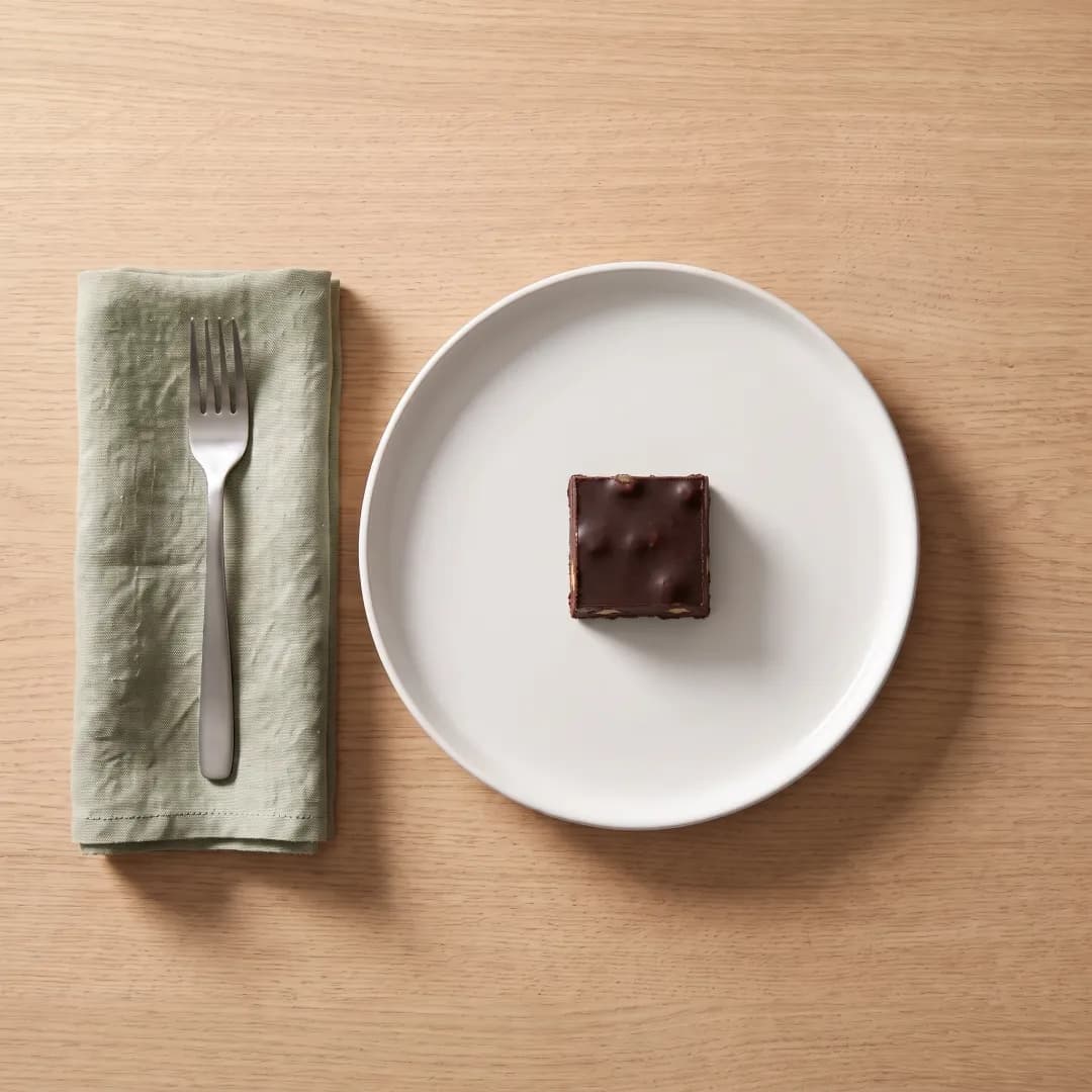 A square of chocolate walnut fudge on a white plate