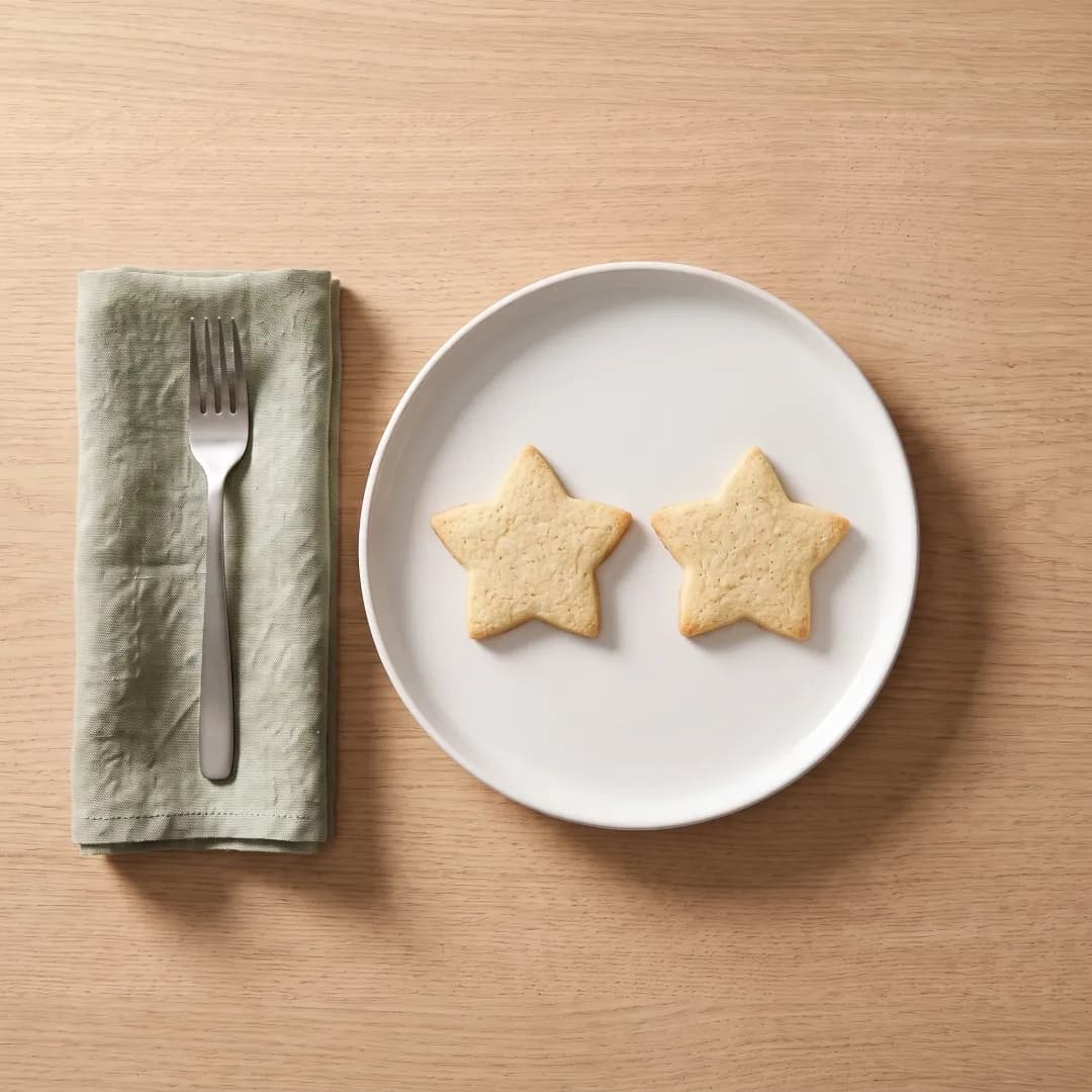 Two allulose-sweetened star-shaped Christmas cookies on a white plate