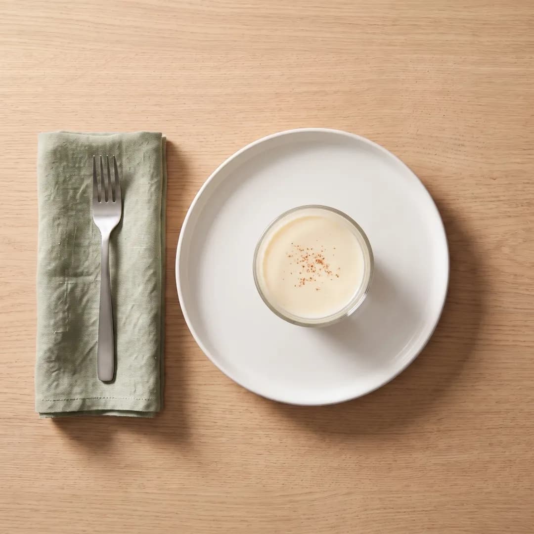 Glass of allulose-sweetened eggnog with a pinch of nutmeg