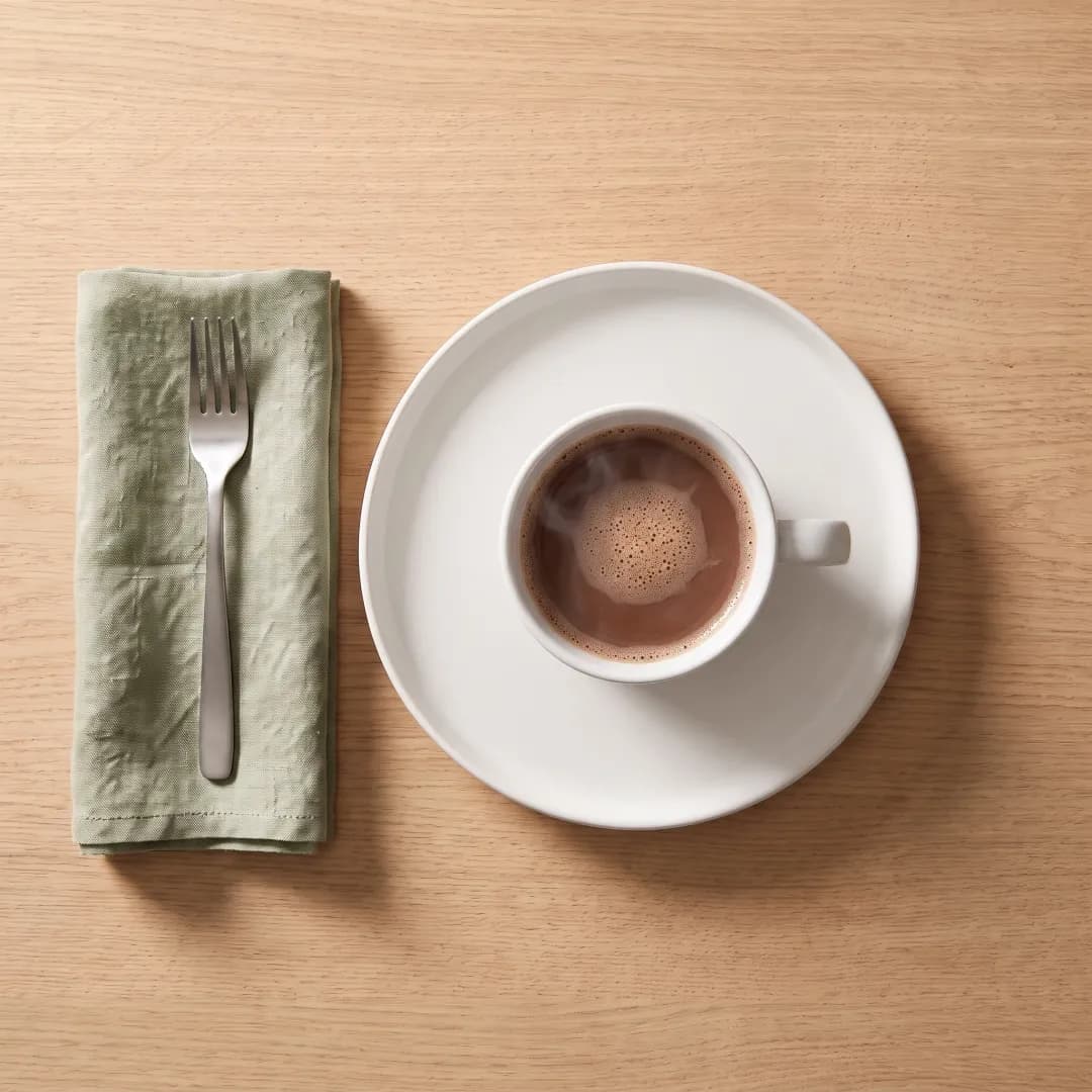 Mug of allulose-sweetened hot chocolate on a white plate
