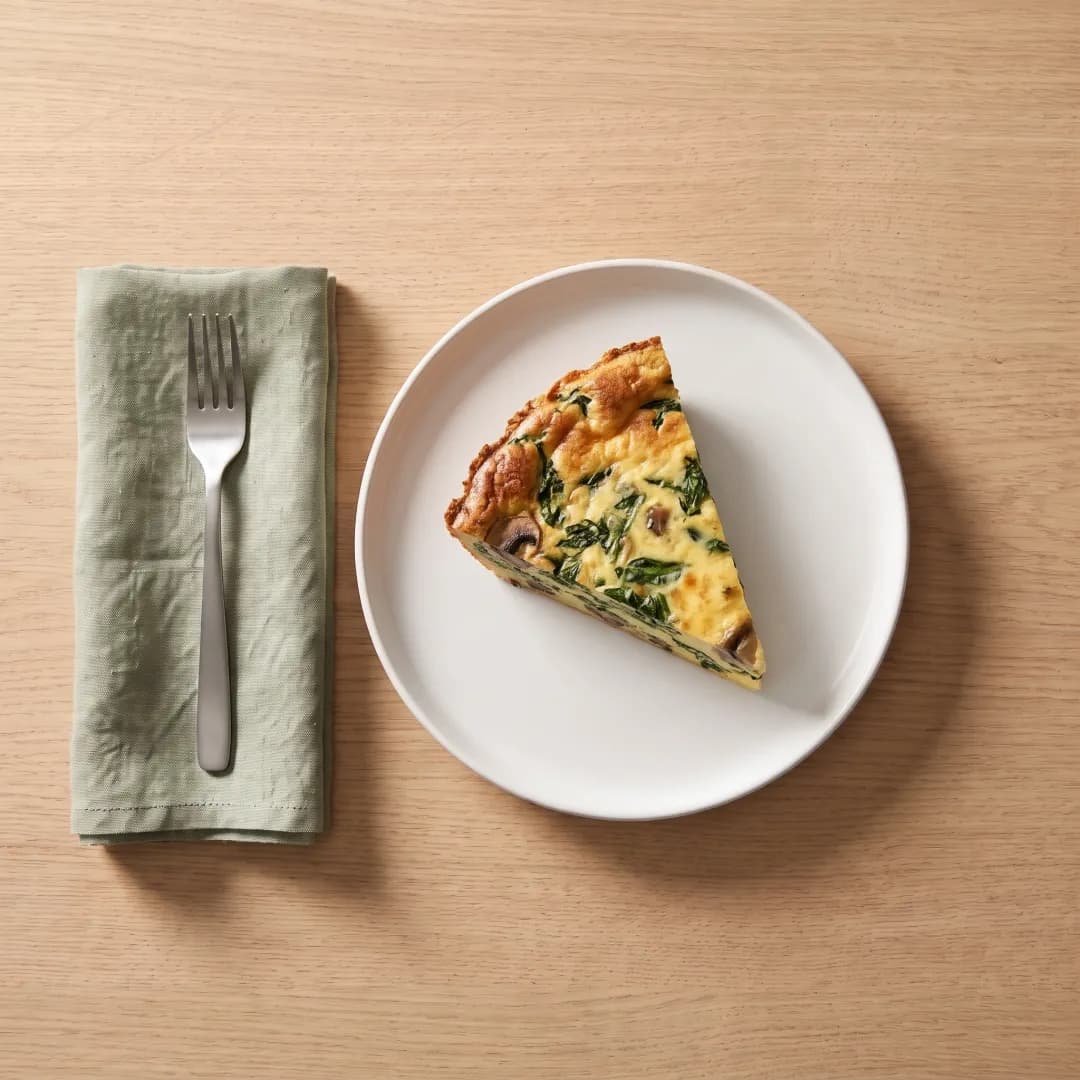 A wedge of crustless spinach and mushroom quiche