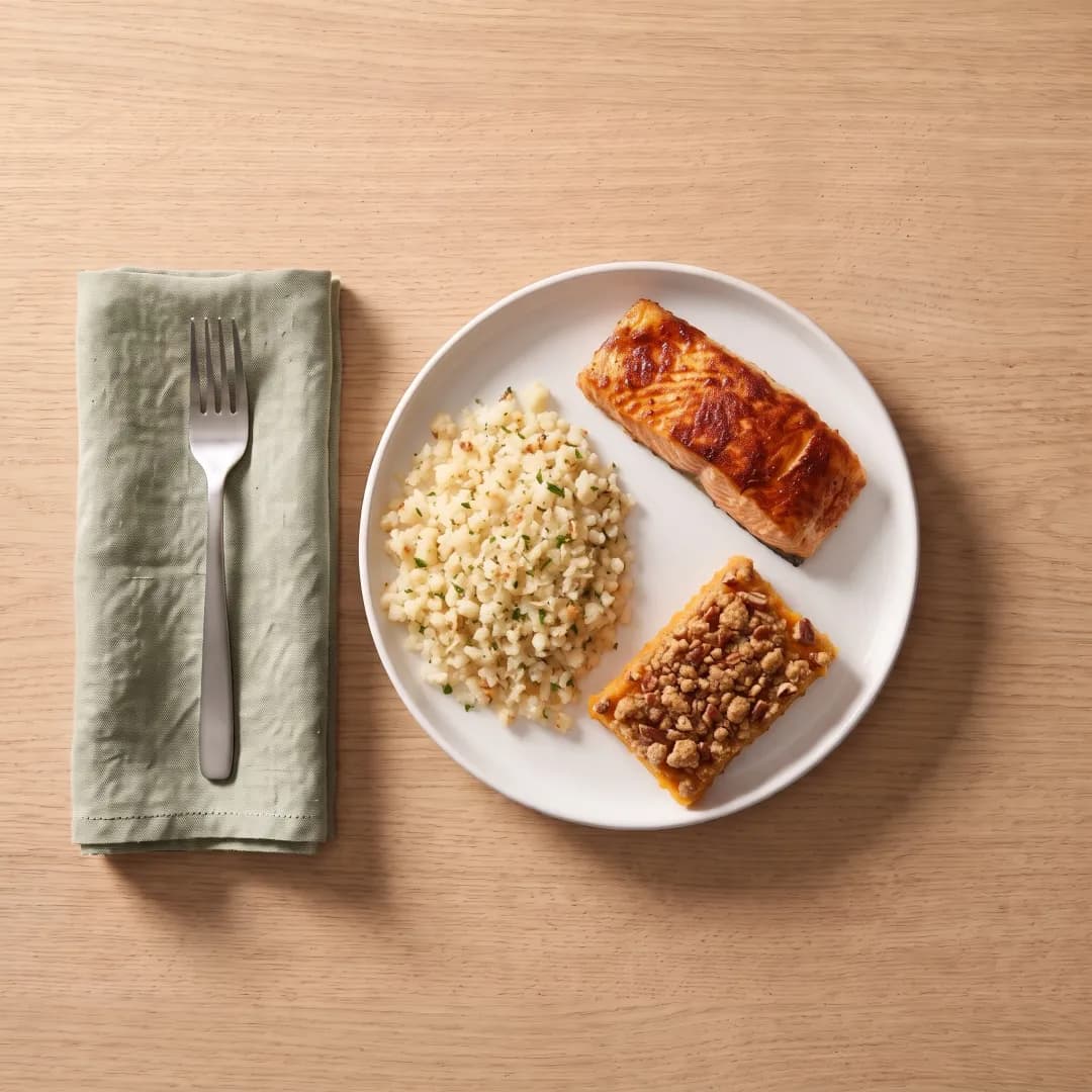 Plate with cauliflower rice, salmon and sweet potato casserole