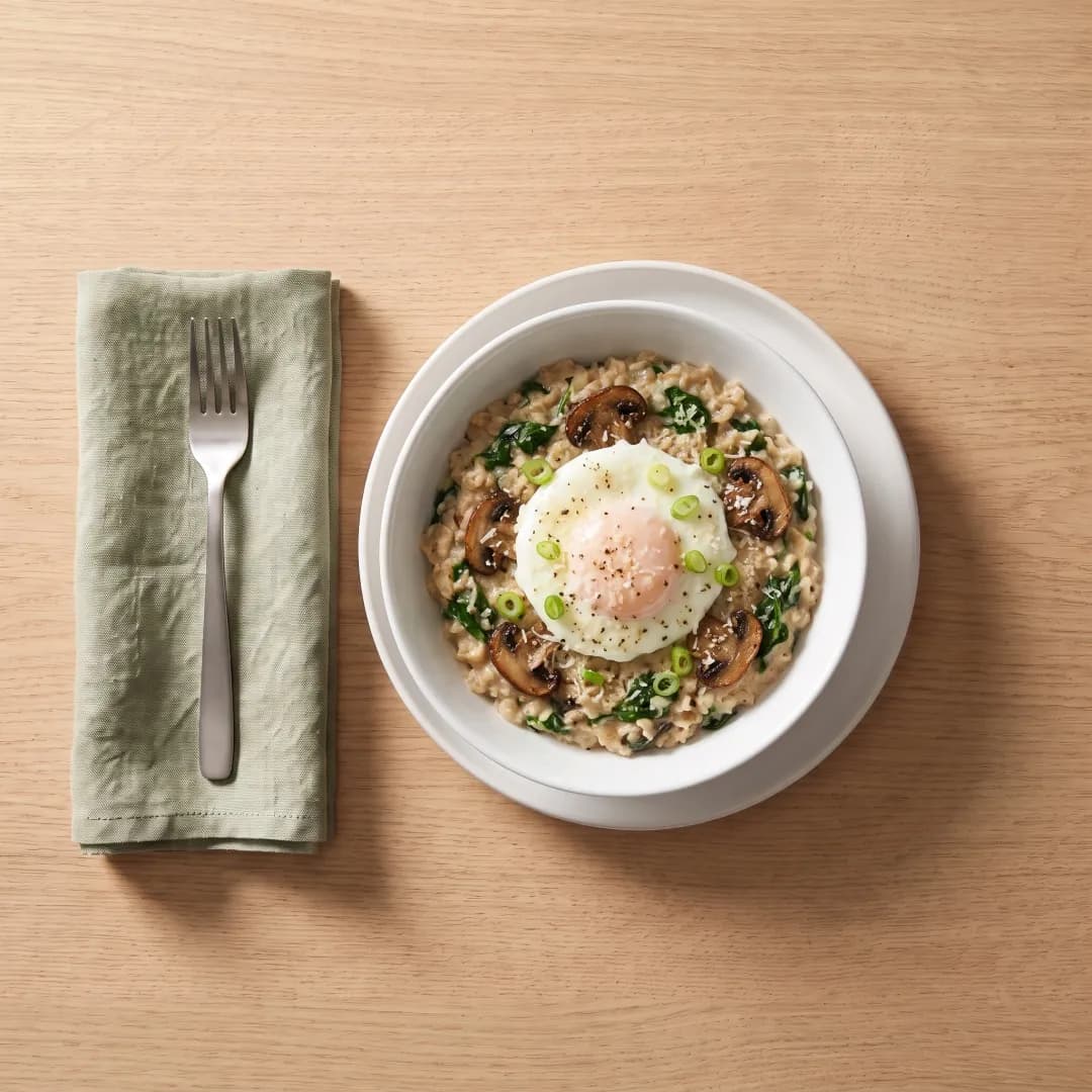 Bowl of savory oatmeal with a fried egg and spinach