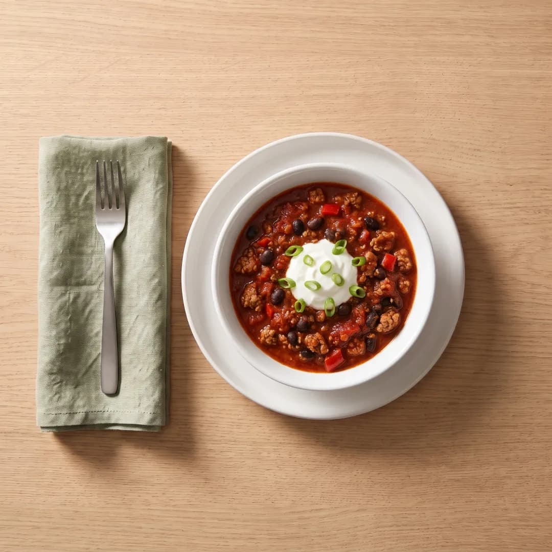 Bowl of turkey chili with yogurt and scallions